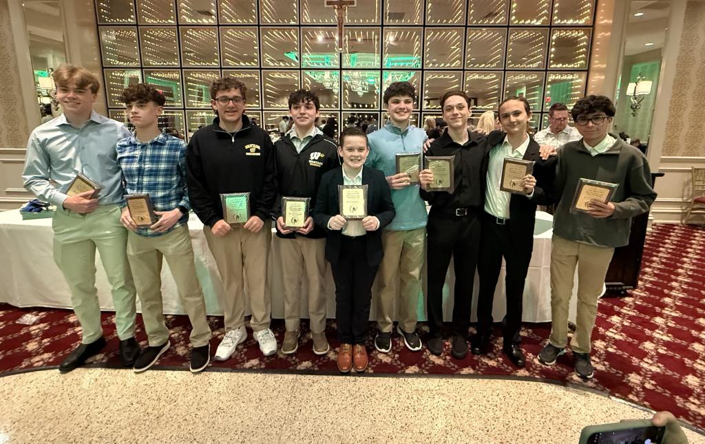 boys holding plaques standing in front of table